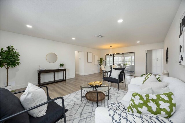 living area featuring visible vents, recessed lighting, light wood finished floors, and baseboards