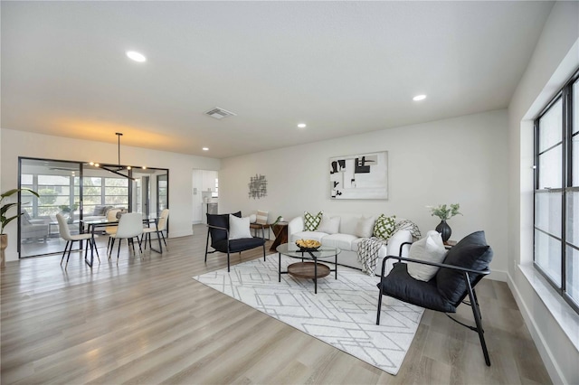 living room featuring baseboards, recessed lighting, wood finished floors, and visible vents
