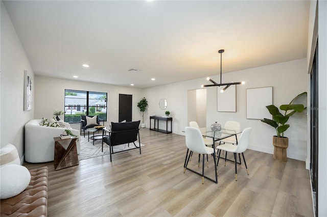 dining area featuring light wood-style floors, recessed lighting, and a chandelier