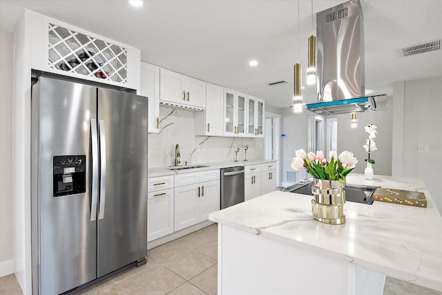 kitchen with island exhaust hood, a sink, glass insert cabinets, stainless steel appliances, and white cabinetry