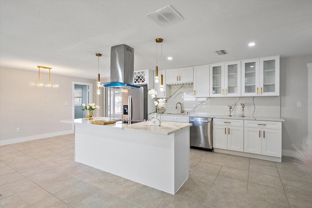 kitchen featuring visible vents, island range hood, white cabinetry, a sink, and appliances with stainless steel finishes