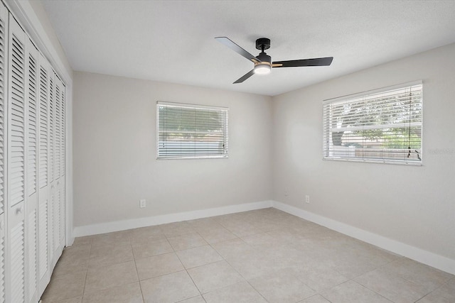 unfurnished bedroom with baseboards, multiple windows, and a closet