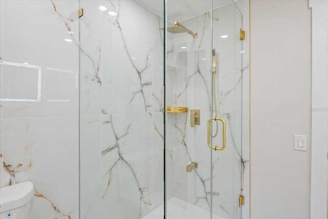 bathroom featuring a marble finish shower and toilet