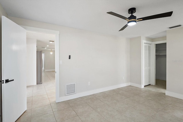 unfurnished bedroom with visible vents, baseboards, light tile patterned floors, and a closet
