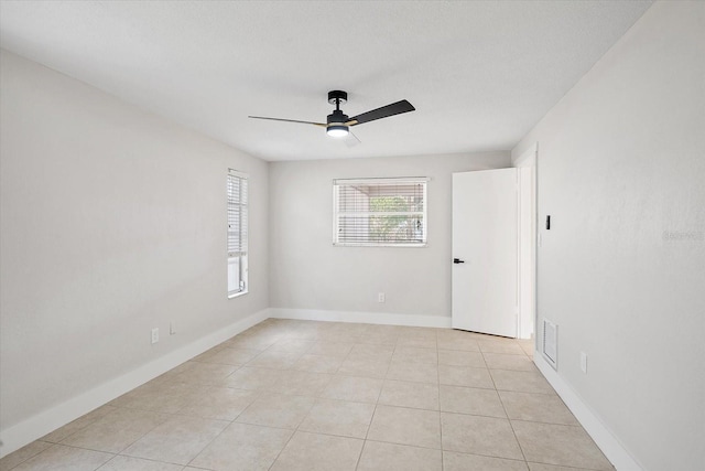 unfurnished room with visible vents, a ceiling fan, baseboards, and light tile patterned flooring