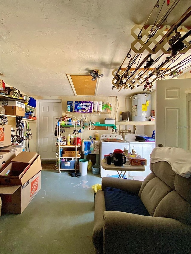 storage room featuring water heater, washing machine and dryer, and attic access