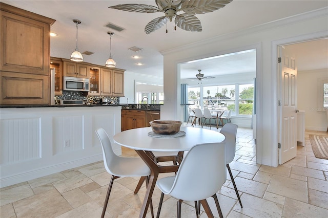 10108 Kingfisher Rd E, Bradenton, FL 34209 - dining space with ceiling fan, ornamental molding, plenty of natural light, stone tile flooring, and recessed lighting