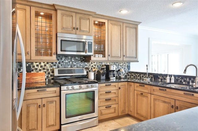 10108 Kingfisher Rd E, Bradenton, FL 34209 - kitchen featuring appliances with stainless steel finishes, a sink, decorative backsplash, glass insert cabinets, and dark stone countertops