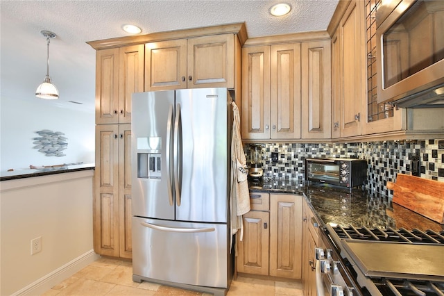 10108 Kingfisher Rd E, Bradenton, FL 34209 - kitchen featuring stainless steel appliances, decorative backsplash, baseboards, dark stone counters, and a textured ceiling