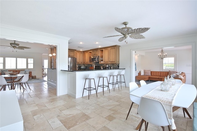10108 Kingfisher Rd E, Bradenton, FL 34209 - dining area featuring ceiling fan, a chandelier, stone tile flooring, recessed lighting, and crown molding