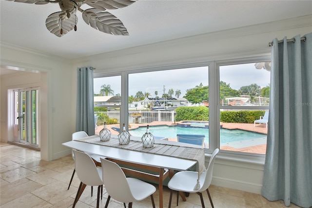 10108 Kingfisher Rd E, Bradenton, FL 34209 - dining area featuring baseboards, ceiling fan, stone tile floors, and plenty of natural light