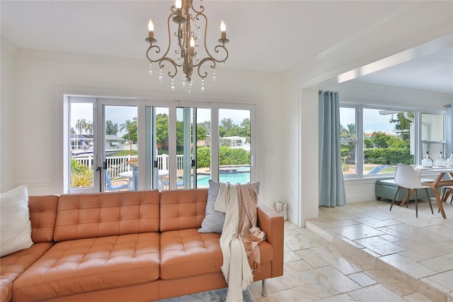 10108 Kingfisher Rd E, Bradenton, FL 34209 - living room featuring stone tile flooring, a chandelier, and crown molding