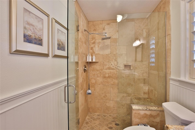 10108 Kingfisher Rd E, Bradenton, FL 34209 - full bathroom featuring a decorative wall, toilet, a shower stall, and wainscoting