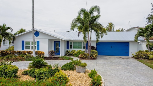 10108 Kingfisher Rd E, Bradenton, FL 34209 - ranch-style house with stucco siding, concrete driveway, a garage, and metal roof