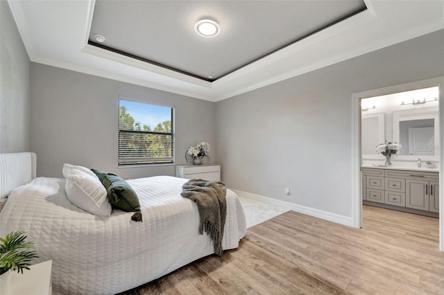8123 Wawana Rd, North Port, FL 34287 - bedroom featuring crown molding, baseboards, ensuite bathroom, light wood-type flooring, and a tray ceiling