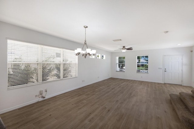 unfurnished living room with baseboards, ceiling fan with notable chandelier, wood finished floors, and visible vents