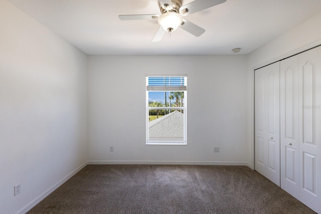 unfurnished bedroom with a closet, carpet flooring, baseboards, and a ceiling fan
