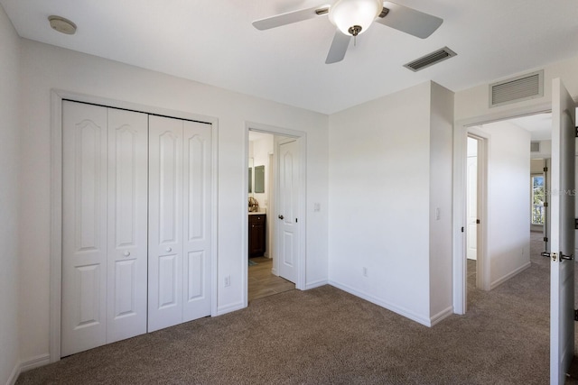 unfurnished bedroom featuring visible vents, carpet flooring, baseboards, and a closet