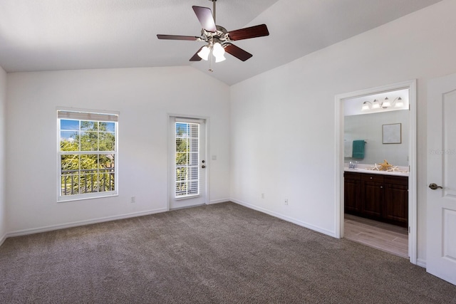 unfurnished bedroom with access to outside, light colored carpet, baseboards, ensuite bathroom, and vaulted ceiling