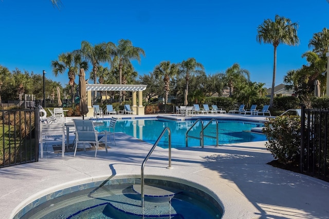 community pool featuring fence, a community hot tub, a patio area, and a pergola