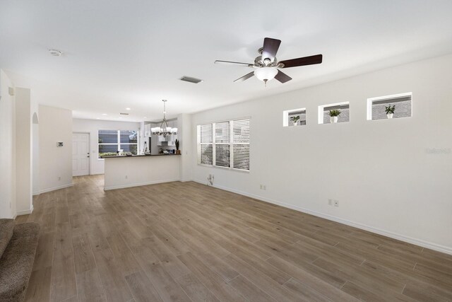5526 River Sound Ter, Bradenton, FL 34208 - unfurnished living room with a chandelier, ceiling fan, wood finished floors, baseboards, and recessed lighting