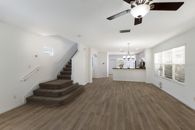 5526 River Sound Ter, Bradenton, FL 34208 - unfurnished living room featuring a chandelier, stairway, wood finished floors, ceiling fan, and recessed lighting
