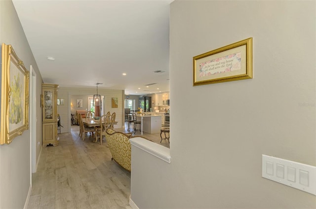 hall featuring recessed lighting, baseboards, and light wood-style flooring