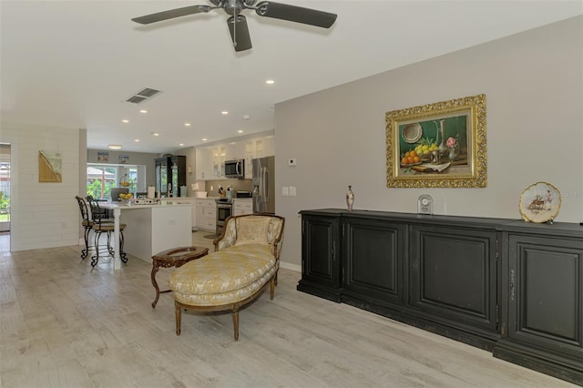 sitting room with a ceiling fan, visible vents, recessed lighting, and light wood-style floors