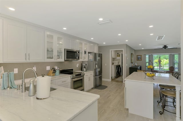 kitchen featuring appliances with stainless steel finishes, white cabinets, recessed lighting, and visible vents