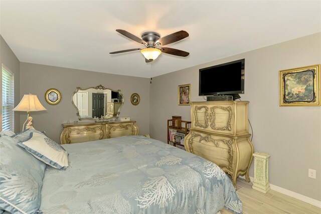 bedroom with a ceiling fan, baseboards, and wood finished floors