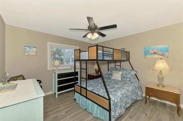 bedroom featuring baseboards, light wood-style flooring, and ceiling fan