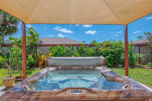 view of pool featuring a fenced backyard and a hot tub
