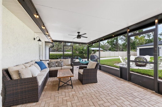 sunroom with ceiling fan, rail lighting, and an outdoor hangout area