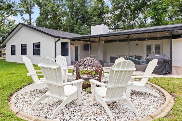 back of property with stucco siding, french doors, a chimney, a patio area, and a yard