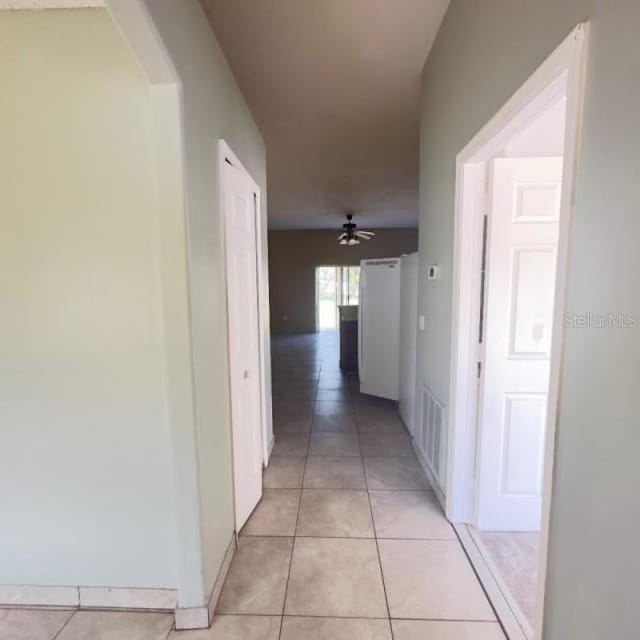 hallway with visible vents and light tile patterned floors
