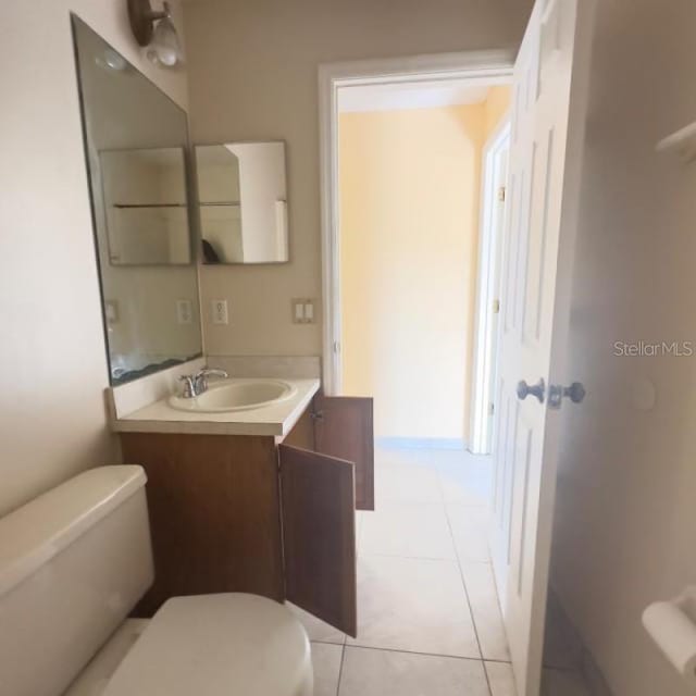 bathroom featuring toilet, tile patterned floors, and vanity
