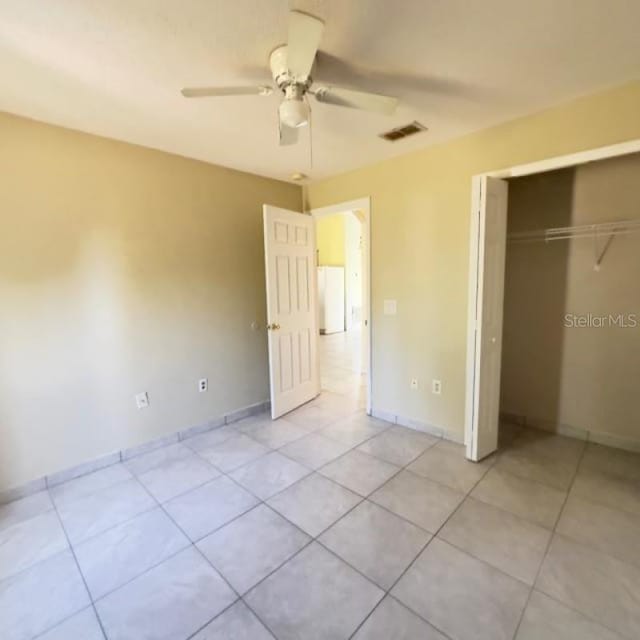 unfurnished bedroom featuring a closet, baseboards, light tile patterned flooring, and visible vents