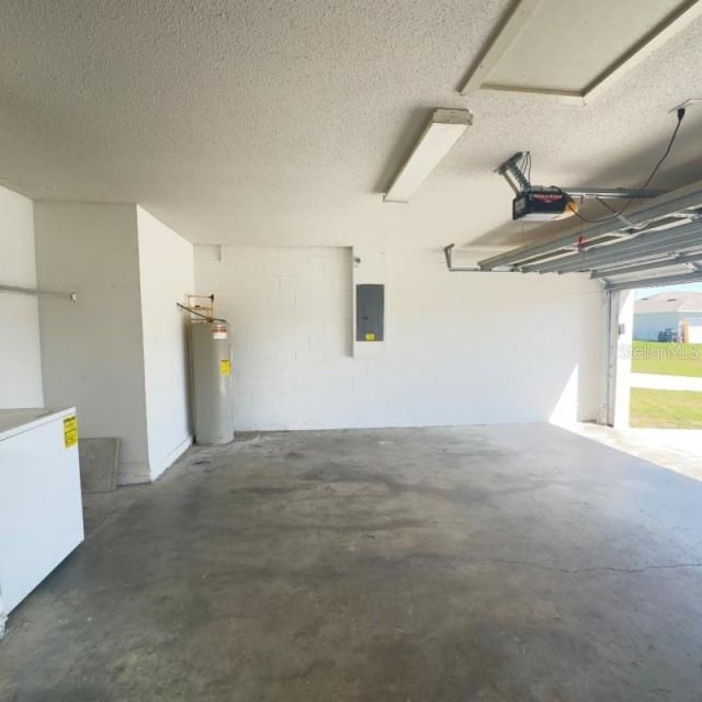garage with water heater, a garage door opener, refrigerator, and electric panel