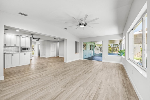 1680 Lemon Bay Dr, Venice, FL 34293 - unfurnished living room featuring ceiling fan, lofted ceiling, baseboards, and light wood-type flooring
