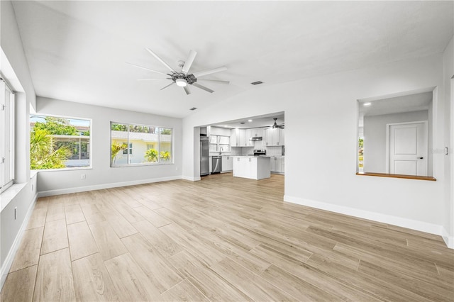 1680 Lemon Bay Dr, Venice, FL 34293 - unfurnished living room featuring ceiling fan, lofted ceiling, baseboards, and light wood-type flooring