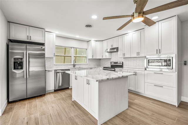 1680 Lemon Bay Dr, Venice, FL 34293 - kitchen featuring stainless steel appliances, a sink, under cabinet range hood, recessed lighting, and white cabinetry