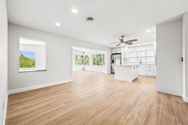 1680 Lemon Bay Dr, Venice, FL 34293 - unfurnished living room with healthy amount of natural light, recessed lighting, a sink, a ceiling fan, and baseboards