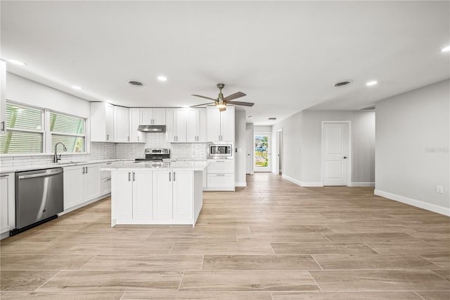 1680 Lemon Bay Dr, Venice, FL 34293 - kitchen featuring appliances with stainless steel finishes, under cabinet range hood, a sink, recessed lighting, and a kitchen island