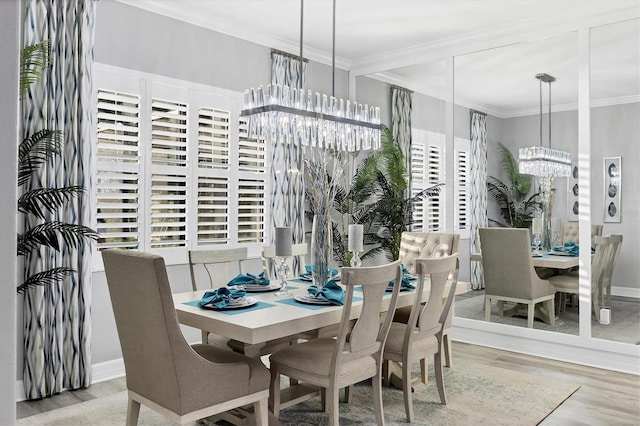 dining room featuring crown molding, baseboards, a chandelier, and wood finished floors