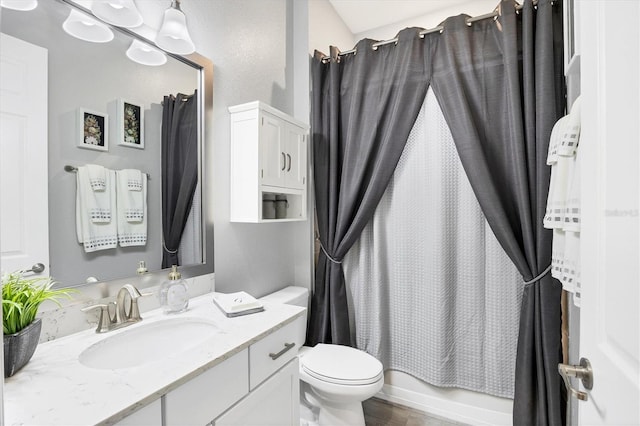 full bath featuring vanity, shower / tub combo, wood finished floors, and toilet