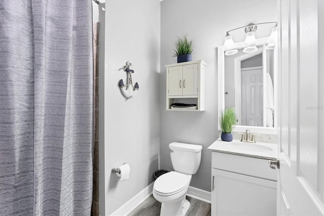 bathroom featuring vanity, wood finished floors, curtained shower, toilet, and baseboards
