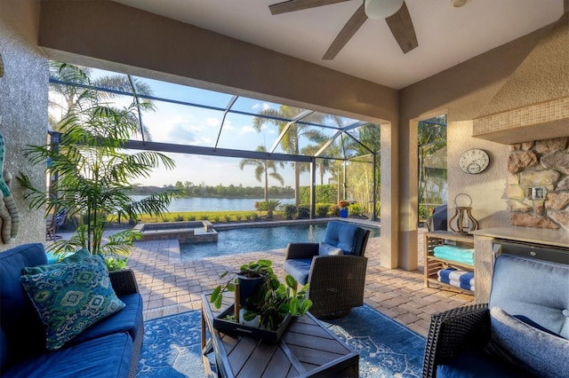 view of patio / terrace with a water view, a lanai, ceiling fan, and an outdoor pool