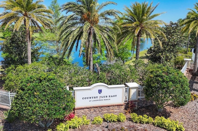 community / neighborhood sign featuring fence and a water view