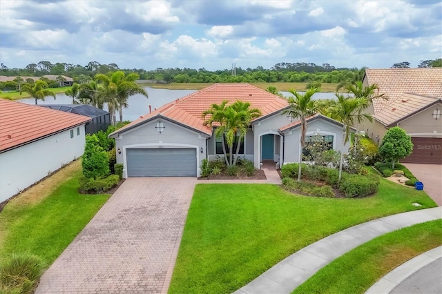 mediterranean / spanish home featuring a front lawn, stucco siding, an attached garage, a water view, and driveway