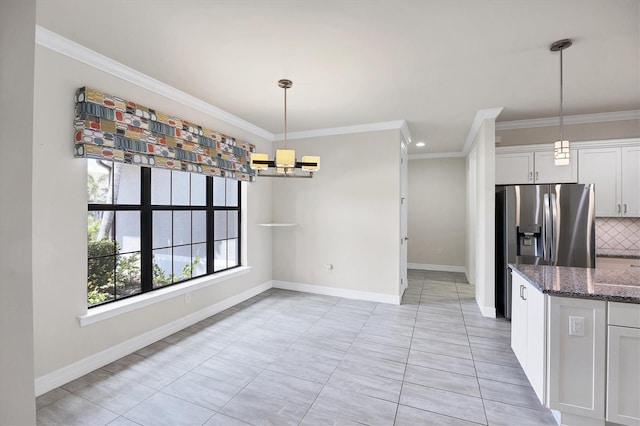 kitchen with ornamental molding, dark stone counters, and white cabinetry